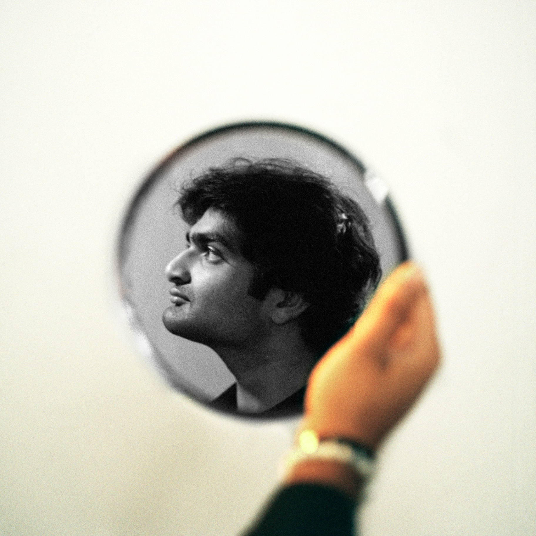 Eshan Agarwal portrait held in a small round mirror
